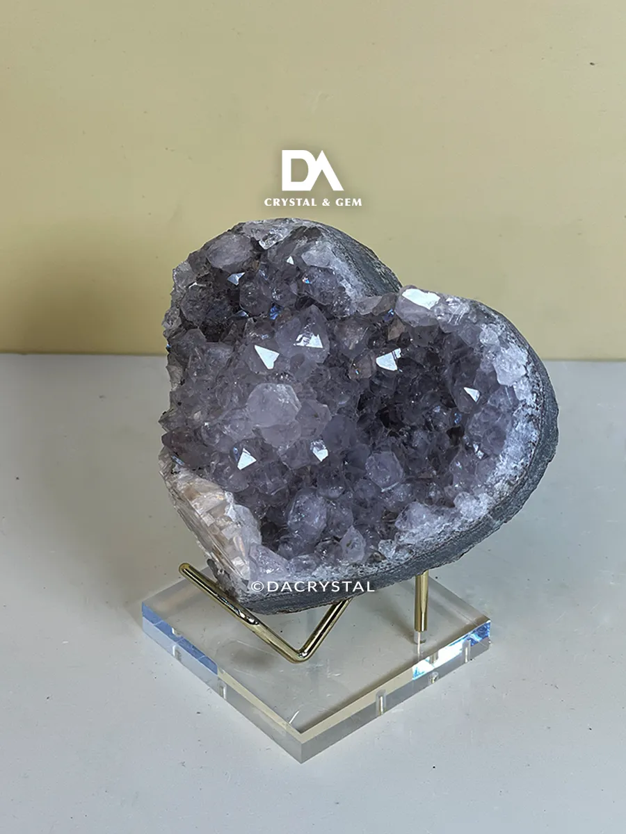 Polished heart-shaped Amethyst mineral with deep purple hues and a smooth crystalline appearance